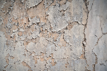 old peeling plaster on the wall in the bright sunlight on the side