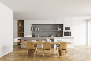 White kitchen interior with dining table and chairs on parquet floor