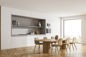 Light kitchen interior with dining table and chairs on wooden floor, window