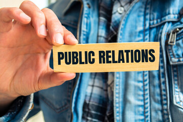 Man holding a white notepad with text Public Relations, business concept
