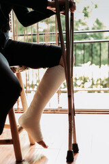 Close-up of a woman with a broken ankle, sitting on a chair