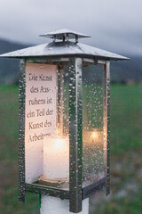 Laterne mit Zitat und Kerze in der Natur bei Regen Inspiration