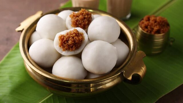 Kozhukatta Pidi in golden bowl Indian milk tea Kerala tea time snack steamed food sweet modak rice dumpling Ganesh Festival India sweet mithai 4K slow motion video footage. christian food Palm sunday