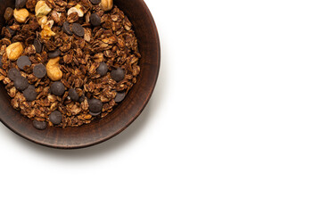 Chocolate granola cereal with nuts in a bowl background.