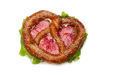 Pretzel with salami and lettuce isolated on a white background.