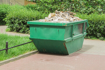 Large metal container with solid household waste