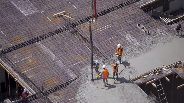 Workers pour concrete on the construction site