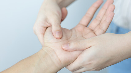 Physical therapy, Female physiotherapist treats hand and joint pain for a male patient attending in clinic, Bone arrangement, Non-surgical medical treatment, Modern medical techniques.