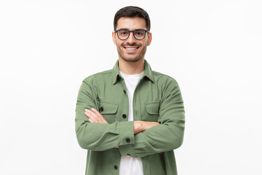 Portrait of young smiling latin man in green shirt and glasses, feeling confident, isolated on gray background