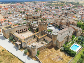 Fototapeta premium Capturas aéreas del municipio de Oropesa y de su famoso castillo medieval en la provincia de Toledo, y los campos castellanos y olivares durante la primavera en un día nublado, campo húmedo y marrón