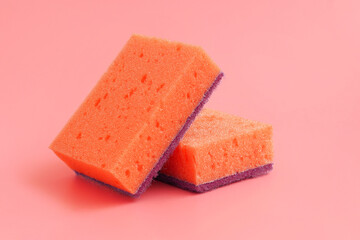 Orange sponges on red background. Dishwashing and household cleaning tools. Tool for having dish and kitchenware clean.