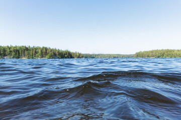 Surface of the lake at warm summer sunny day. Waves on the water.  The lower point of photography.