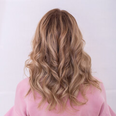 Naklejka premium Female back with long, curly, ombre, blonde hair, in hairdressing salon