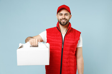 Delivery guy employee man in red cap white T-shirt vest uniform workwear work as dealer courier hold cake dessert in unmarked blank box isolated on pastel blue color background studio Service concept