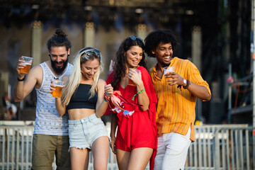 Happy young group of friends attending festivals at summer