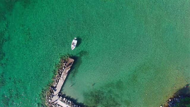 Yacht arriving at the dock, minimalist aerial view