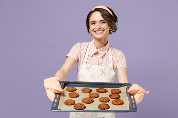 Young satisfied happy housewife housekeeper chef cook baker woman in pink apron showing chocolate...