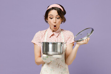 Young amazed impressed housewife housekeeper chef cook baker woman wear pink apron loot at...