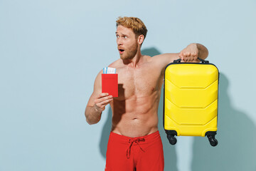 Traveler shocked tourist young man in shorts swimsuit hold passport ticket suitcase bag isolated on...
