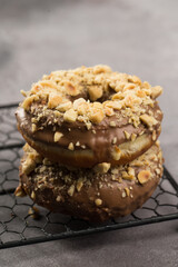 Doughnuts chocolate glazed and nuts covered in composition at studio shot
