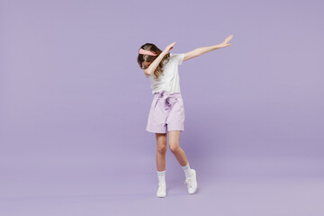 Full length little kid girl 12-13 years old in white shirt doing dab hip hop dance hands move gesture youth sign hide cover face isolated on purple background. Childhood children lifestyle concept