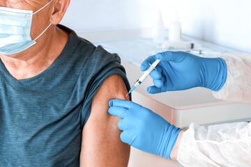 Doctor Vaccinating Senior Man In Clinic. Elderly People Vaccination. Doctor Giving COVID19...
