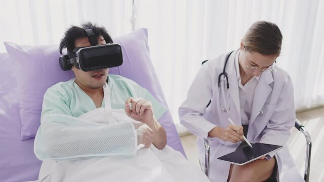 Concept medical treatment with virtual reality glasses technology. Doctor using tablet and camera VR give patient broken arm in Splint. Treat and explain medically hospital. modern health care service