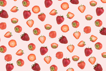 Trendy pattern of whole and cut strawberries on a pink background.