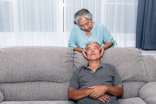Portrait images of Asian elderly couple, Wife doing reflexology on husband's face, to help relax and to lower blood pressure, to relationship Asian family and health care for elderly concept.