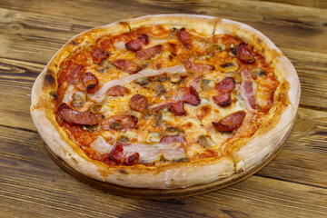 Delicious fresh pizza with sausage, mushrooms and cheese on a wooden table