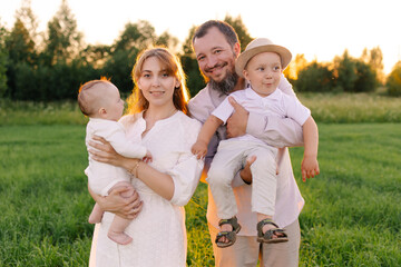Traditional family in light clothes in the field nature. Walk at sunset. Christians. priest with...