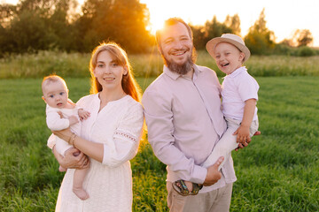 Traditional family in light clothes in the field nature. Walk at sunset. Christians. priest with...