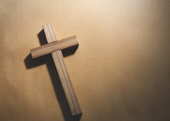 Wooden cross on paper background, Christian symbol concept.