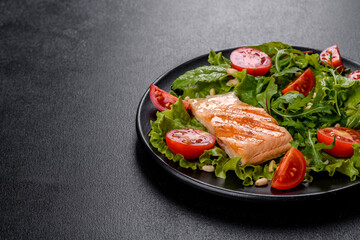 Delicious fresh salad with fish, tomatoes and lettuce leaves