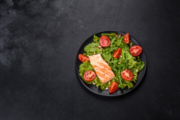 Delicious fresh salad with fish, tomatoes and lettuce leaves