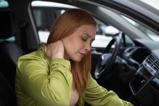 Young woman having neck pain or whiplash injury after car accident