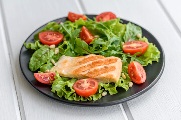 Delicious fresh salad with fish, tomatoes and lettuce leaves