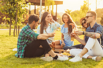 group of friends, chatting and having fun, enjoying a picnic and food outdoors