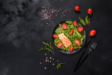 Delicious fresh salad with fish, tomatoes and lettuce leaves