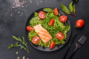 Delicious fresh salad with fish, tomatoes and lettuce leaves