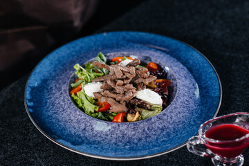 Prepare a delicious fresh salad of tomato greens, cheese, veal and cashew nuts. Delicious healthy food.