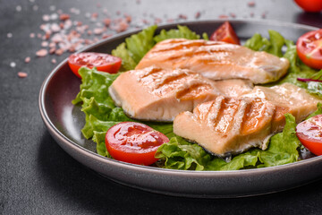 Delicious fresh salad with fish, tomatoes and lettuce leaves