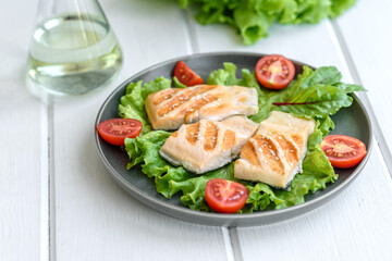 Delicious fresh salad with fish, tomatoes and lettuce leaves