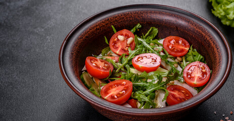 Pieces of chicken, tomatoes and lettuce leaves on a dark concrete background