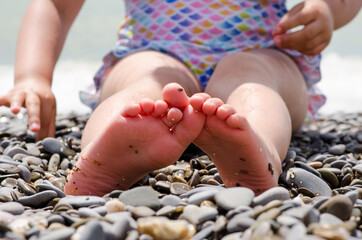 child's heels on the beach on a sunny day by the sea