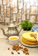 Moroccan or Algerian pancakes named Baghrir in arabic with honey syrup decorated with walnuts and almond 
