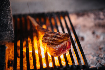 Juicy steak is grilled in a restaurant. Roasting meat in the fire on the grill.
