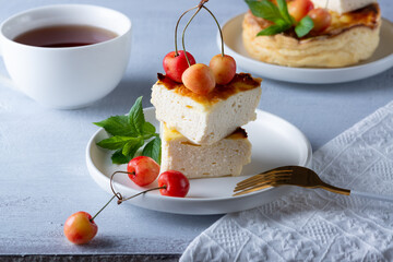  Cottage cheese casserole and sweet cherry on wooden light table. Cottage cheese casserole