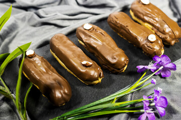  french dessert eclairs with custard and chocolate icing and decorated with hazelnuts 