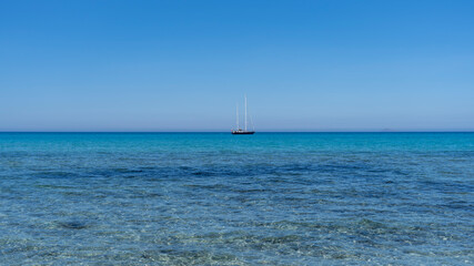 Fototapeta premium Amazing view of a boat in a turquoise and blue sea. General contest of a relaxing ambient. Mediterranean or Caribbean summer place. Sardinia, Italy